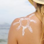 woman with suntan lotion at the beach